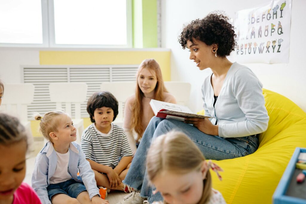 A teacher sitting in front of her students teaching vocabulary to the students