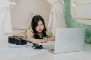 A child using a laptop for music lessons, this is an example of how technology in homeschooling can be beneficial