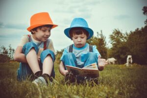 Two children enjoying some holiday reading outdoors